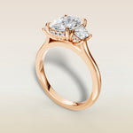 Cushion Three Stone Hidden Halo engagement ring in rose gold, angled view