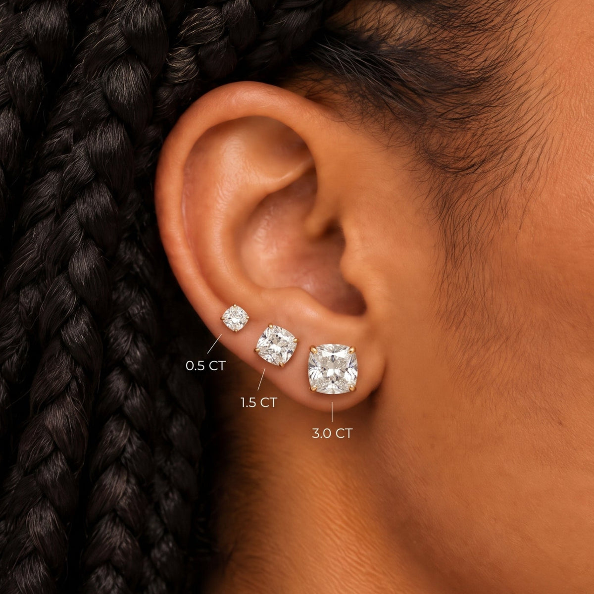 Cushion diamond stud earrings size guide on the ear: 0.5, 1.5 and 3.0 carat