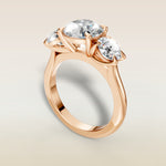 Round Three Stone engagement ring in rose gold, angled view
