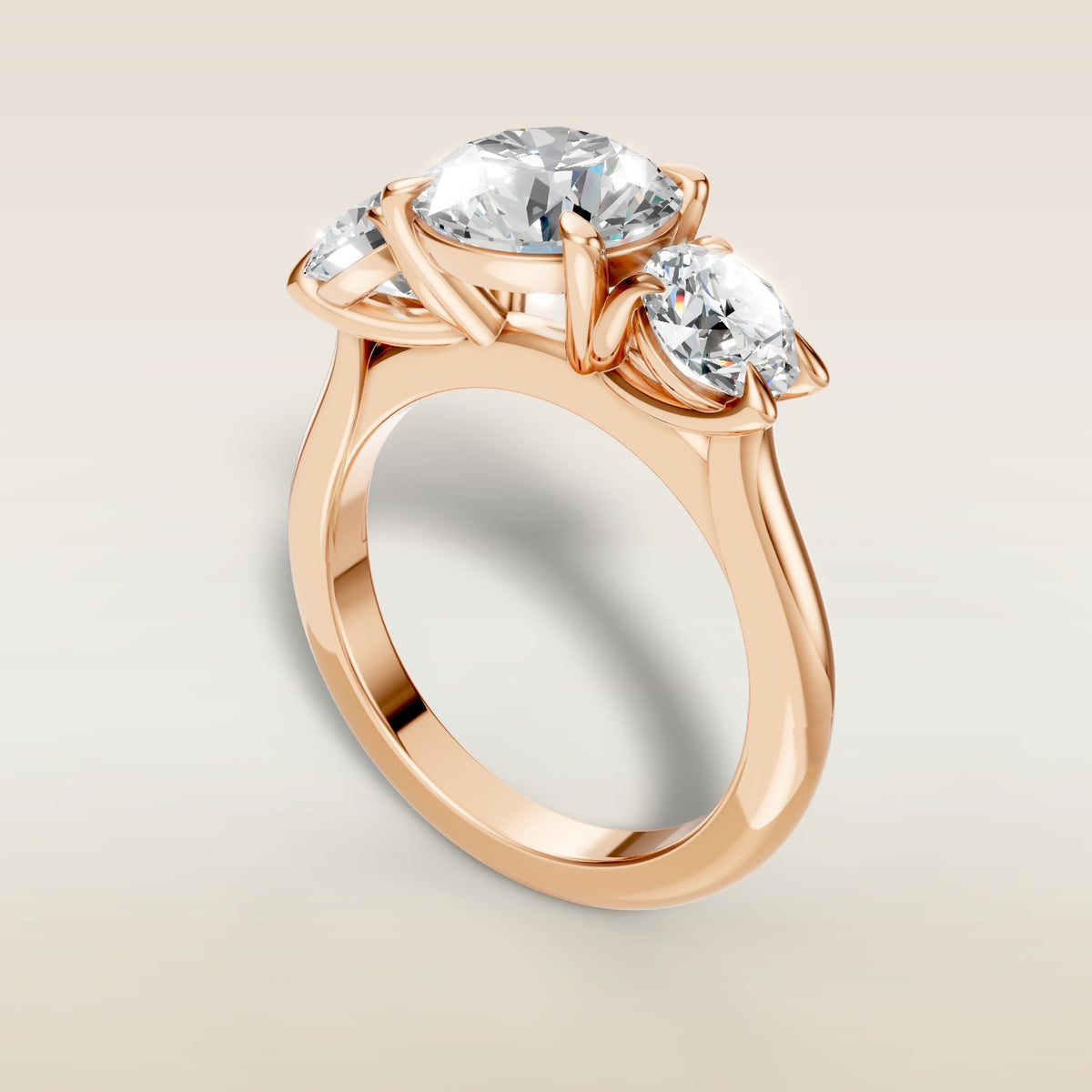 Round Three Stone engagement ring in rose gold, angled view