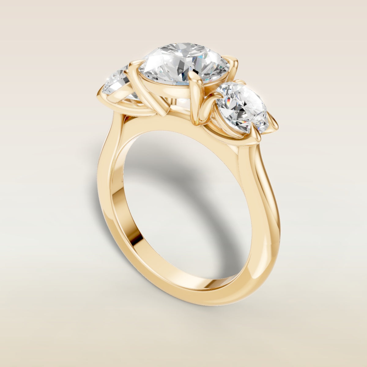 Round Three Stone engagement ring in yellow gold, angled view