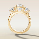Round Three Stone engagement ring in yellow gold, front view