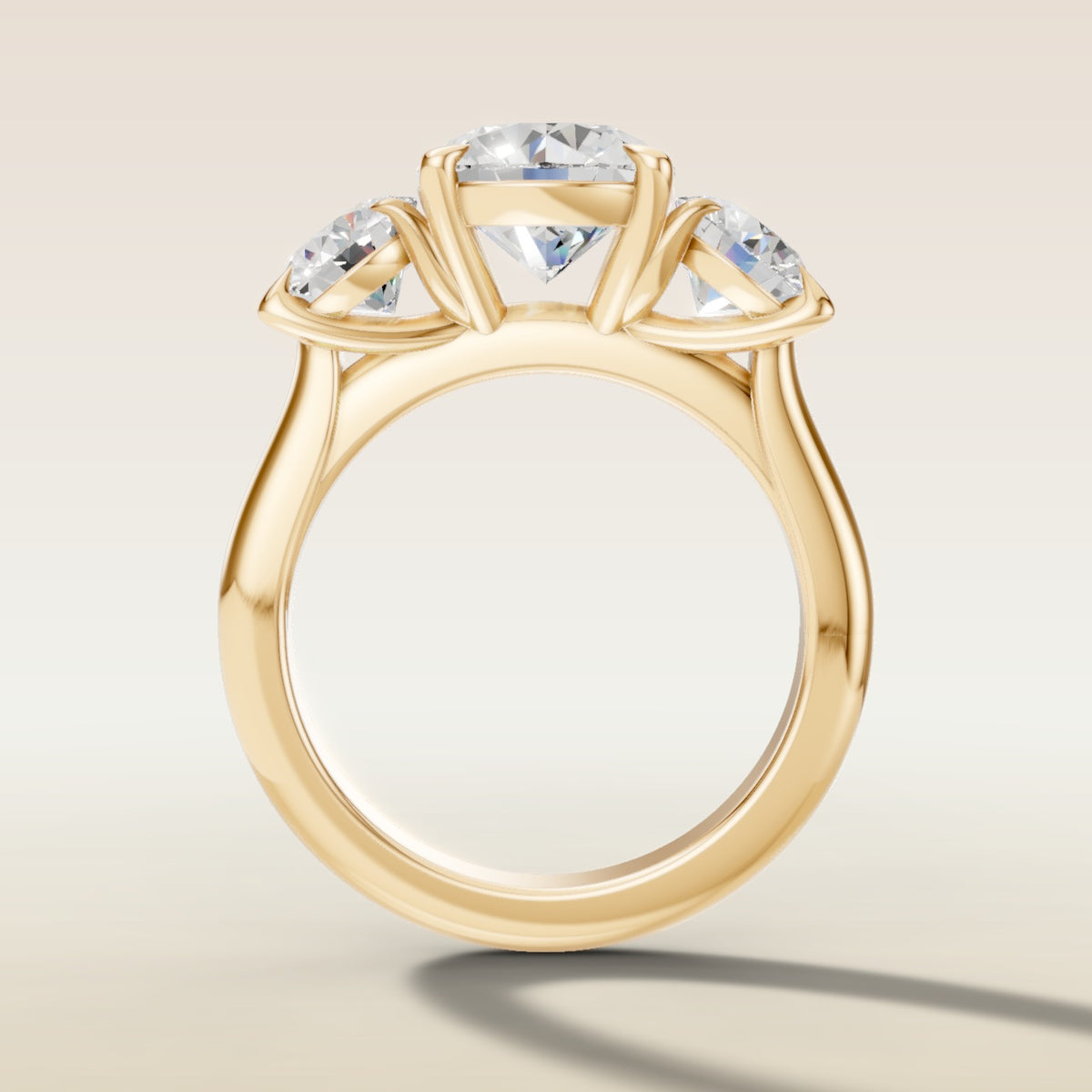 Round Three Stone engagement ring in yellow gold, front view