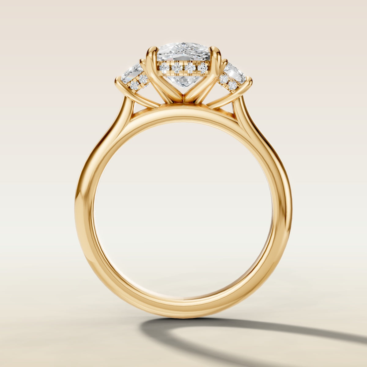 Cushion Three Stone Hidden Halo engagement ring in yellow gold, front view