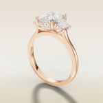 Cushion Three Stone Hidden Halo engagement ring in rose gold, angled side view