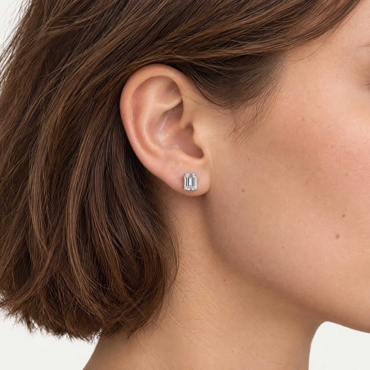 Emerald cut lab grown diamond stud earring worn on the ear
