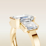 Emerald Three Stone Half Bezel Thick Band engagement ring in yellow gold, basket close up