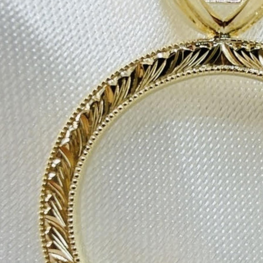 Feathered edge engraving on a yellow gold band, with a milgrain line of tiny beads along its edge