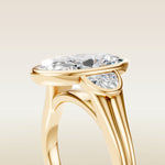 Moval Three Stone Full Bezel engagement ring in yellow gold, basket close up