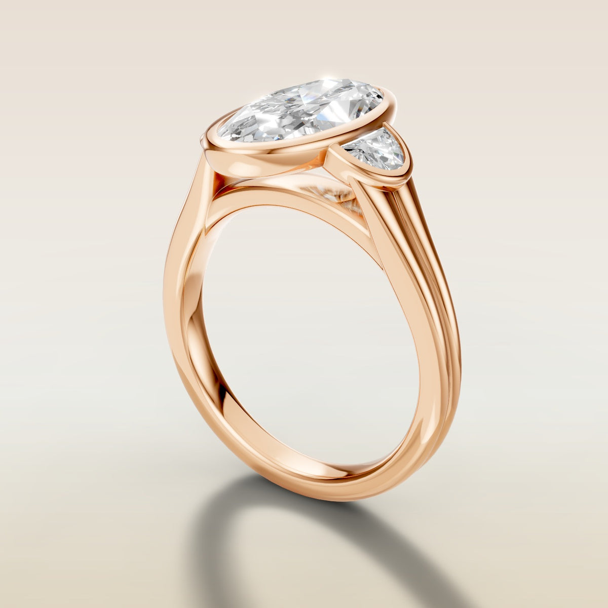 Moval Three Stone Full Bezel engagement ring in rose gold, angled side view
