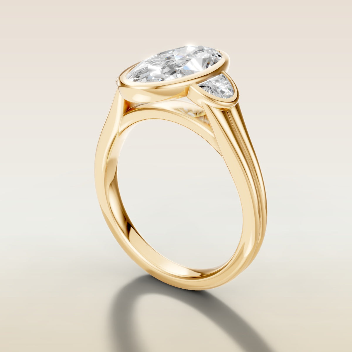 Moval Three Stone Full Bezel engagement ring in yellow gold, angled side view