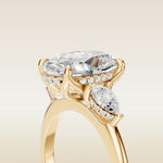 Oval Tulip Three Stone Hidden Halo engagement ring in yellow gold, basket close up