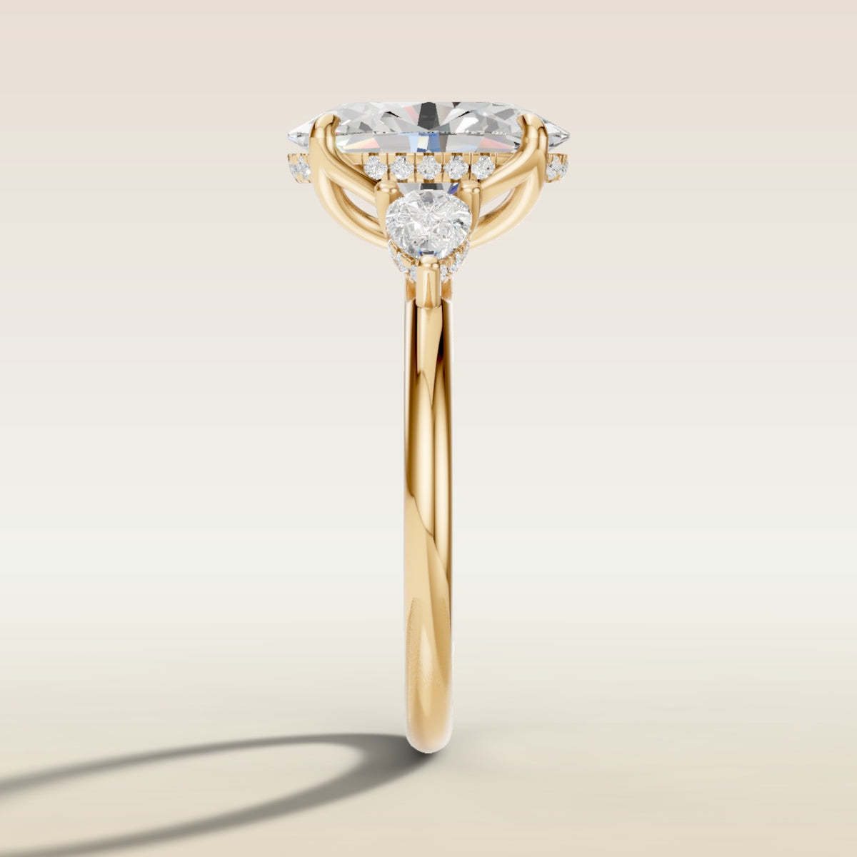 Oval Tulip Three Stone Hidden Halo engagement ring in yellow gold, side profile