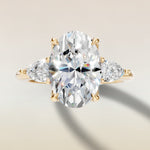 Oval Tulip Three Stone Hidden Halo engagement ring in yellow gold, top view